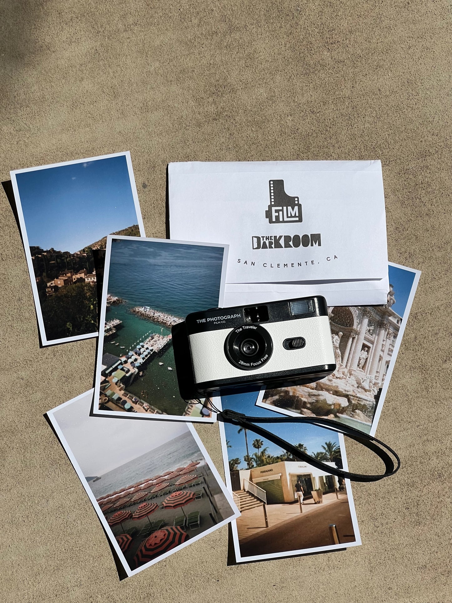 The Traveler white 35mm film camera on top of printed travel photos of Europe